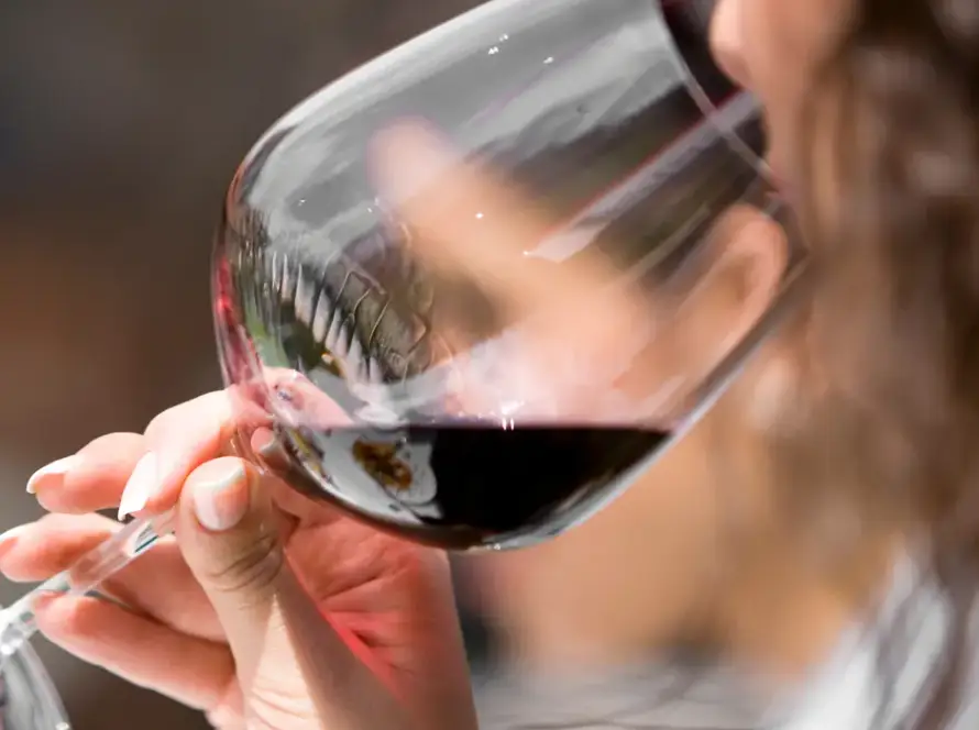 Mujer bebe de una copa vino tinto